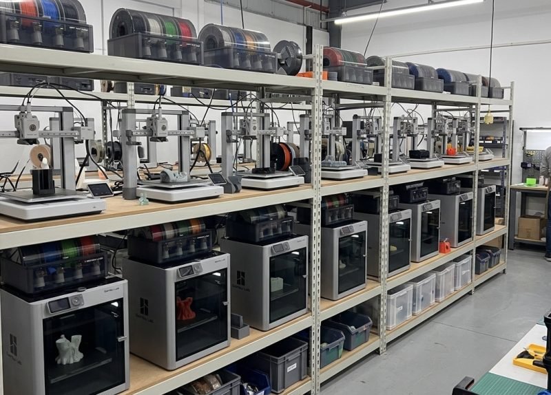 Racks of 3D printers running alongside spools of filament
