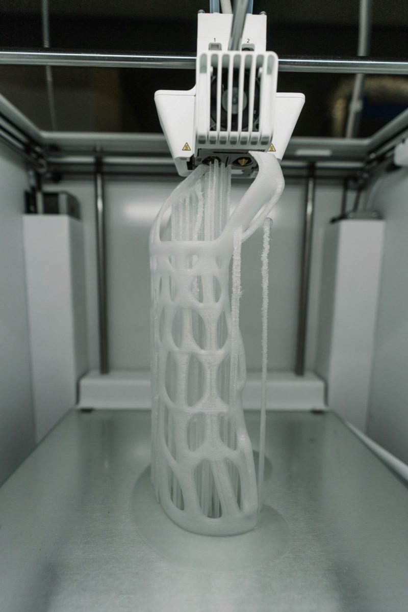 A lattice-structured piece being built up layer by layer on a printer bed